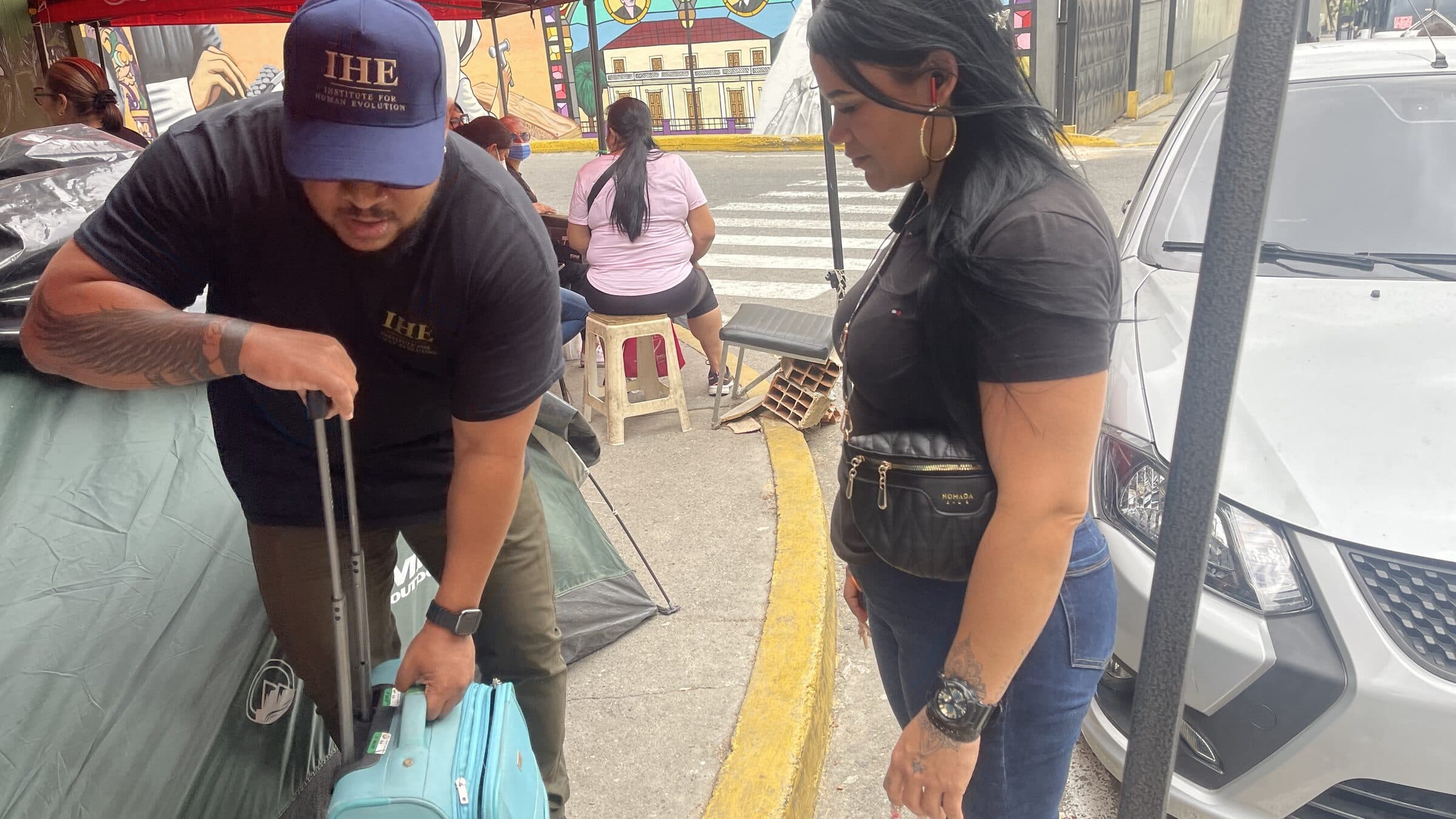An IHE team member arrives at the camp pulling a suitcase loaded with supplies.