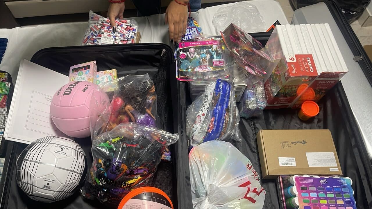 Volunteers packing suitcases with toys, sports balls and art supplies for children affected by the earthquake in Venezuela.